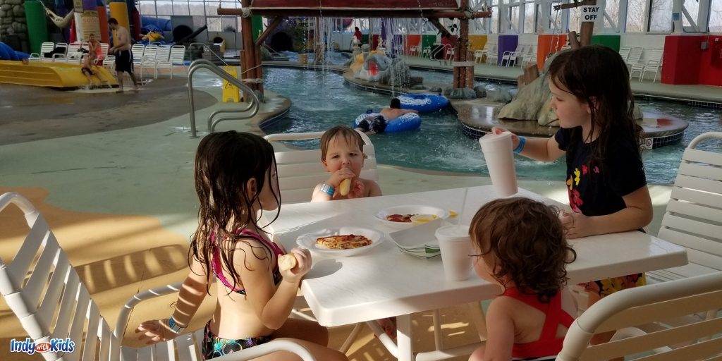 Children eating lunch at the French Lick indoor waterpark, Big Splash adventure. The indoor water park is in the background.