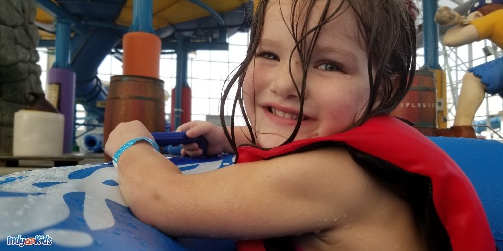 Child on a tube at the French Lick waterpark, Big Splash adventure. The indoor water park is in the background.
