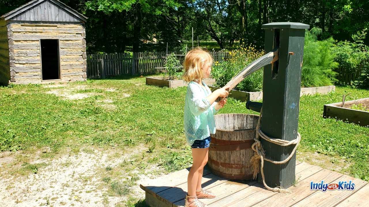 Conner Prairie Homeschool Programs: A girl tries out the historic water pump at Conner Prairie.