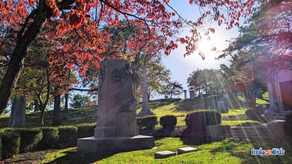 The sun bursts through colorful autumn trees over the Eli Lilly gravesite at Crown Hill Cemetery.