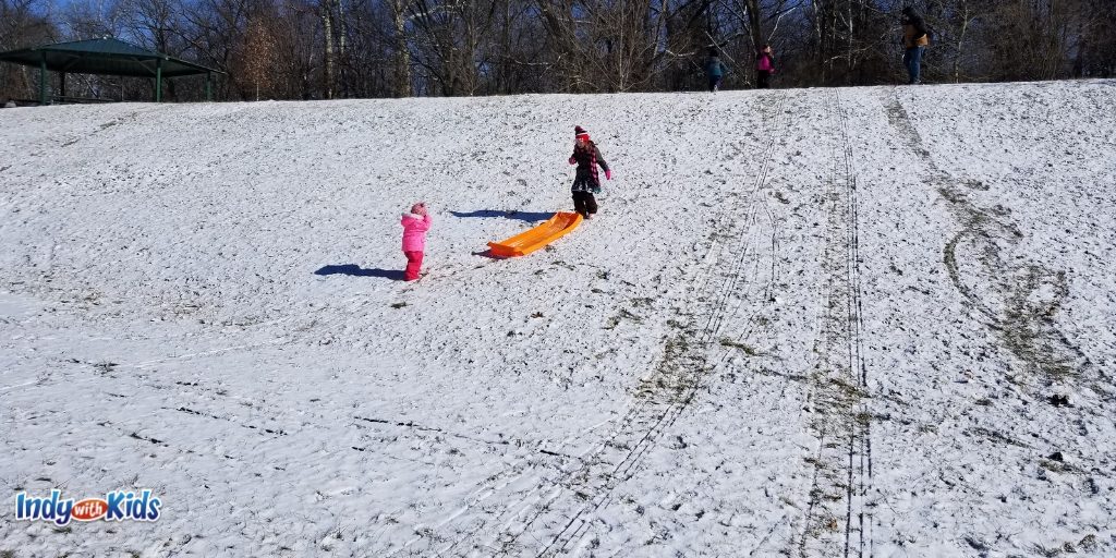 children pulling sled up a hill at indianapolis brookside park