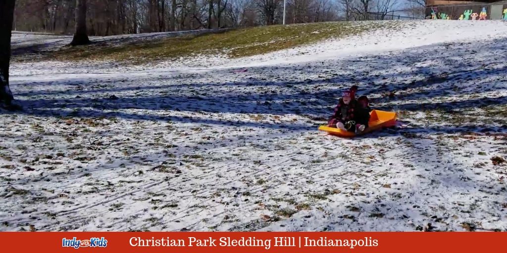 children on a sled at christian park indy sledding hill