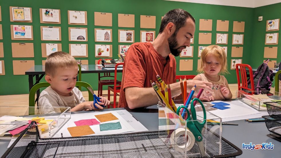 A man and two children use paper scraps and washi tape to create collage art in the Contemporary Gallery at Newfields.