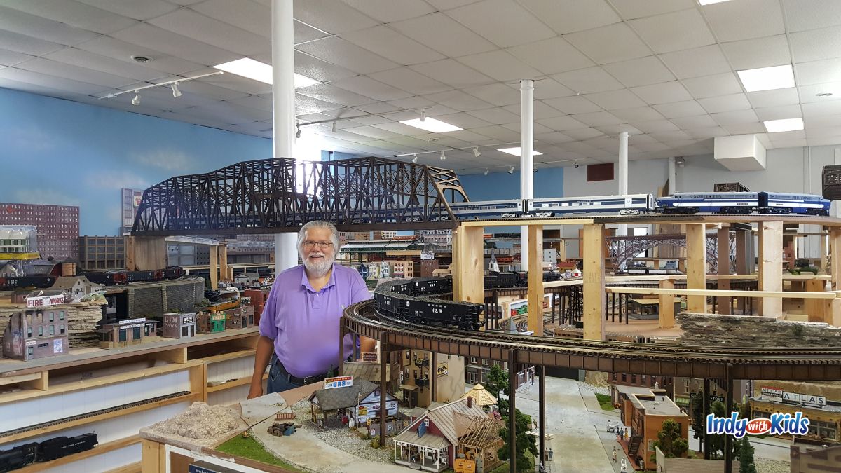Steve Nelson of Mr. Muffin's Trains stands in the midst of bridges and train tracks at his large indoor train layout in Atlanta Indiana.