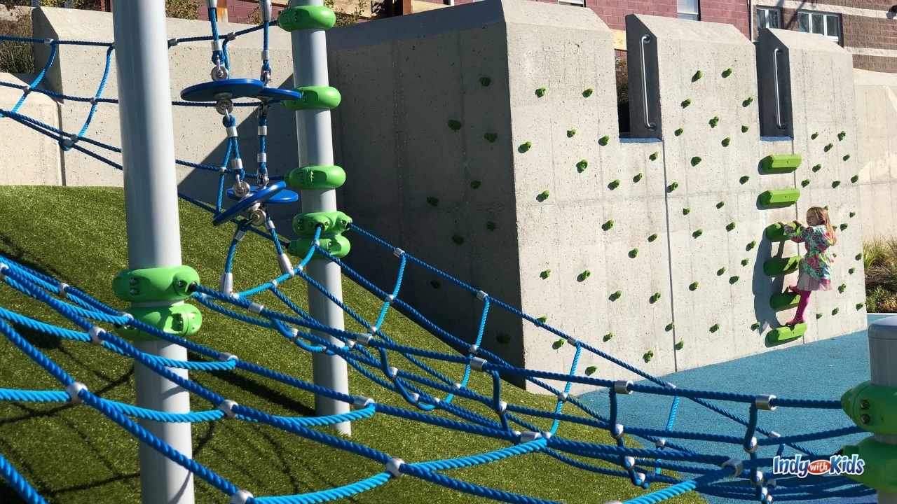 Mud Free Parks Near Me: green faux turf covers a hill near a climbing wall at Old City Park.