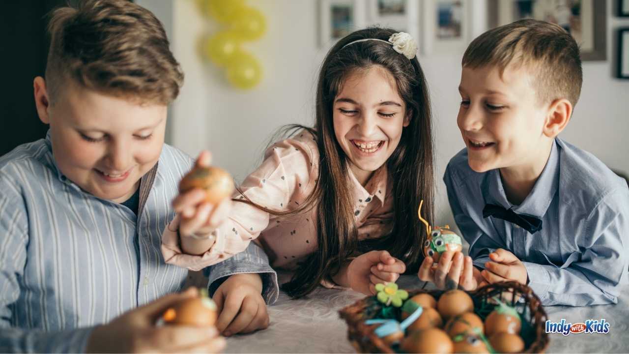 Things to Do on Easter at Home: Children laugh together around a table while decorating Easter eggs with craft supplies.