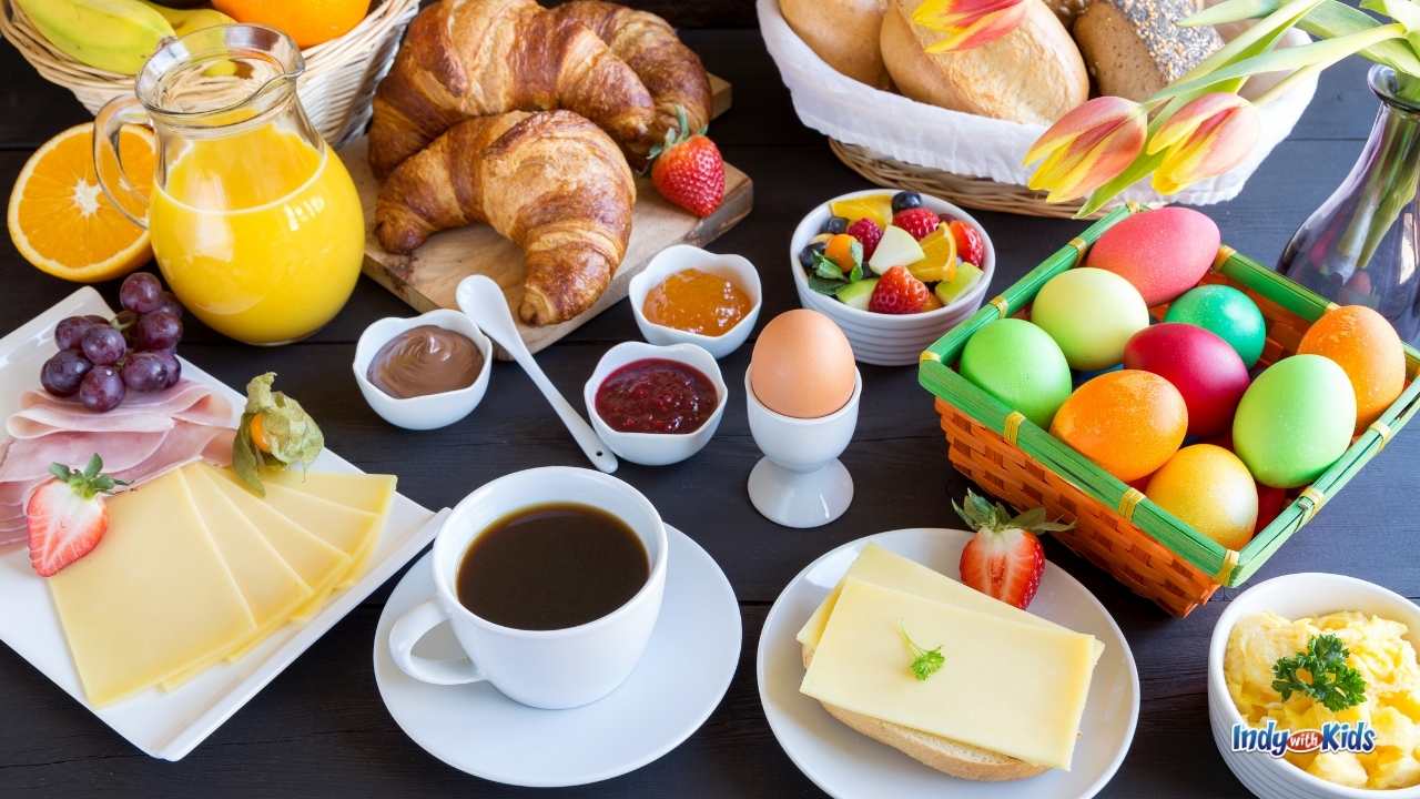 Things to Do on Easter at Home: A generous spread of breakfast foods, including colorful Easter eggs, orange juice, coffee, fruit, and pastries, on a dark table top.