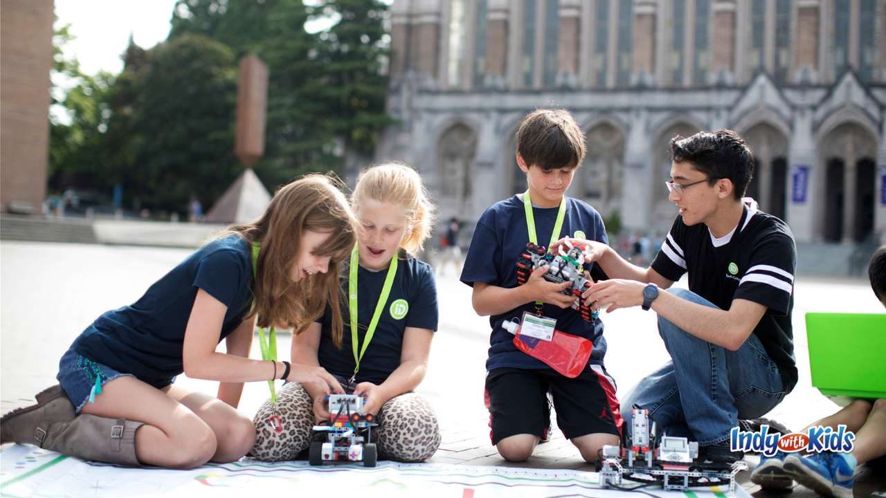 iD Tech a group of students working on robots together outside