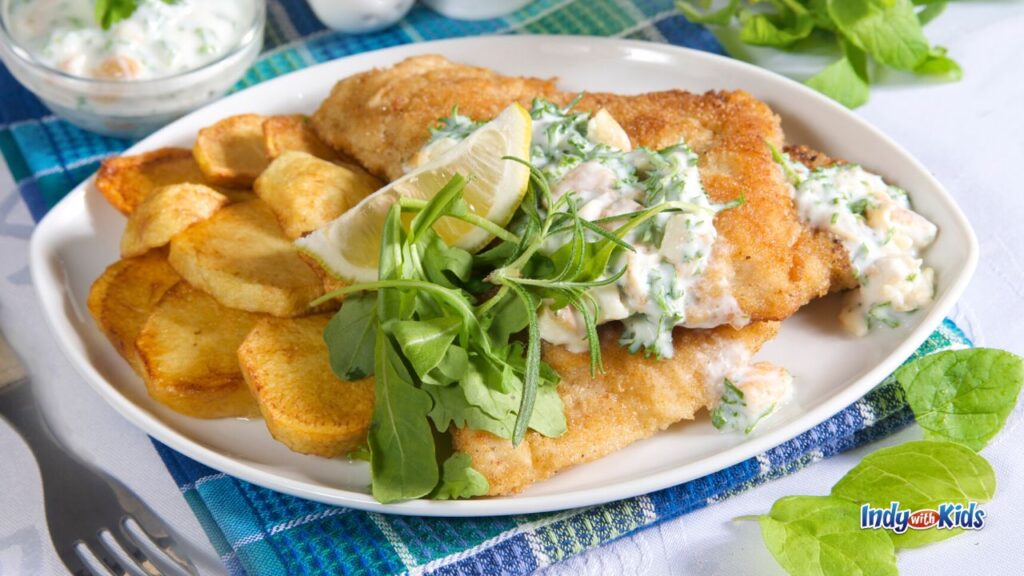 Baked fish or fried fish on a plate with arugula lettuce on a plate during a fish fry near me