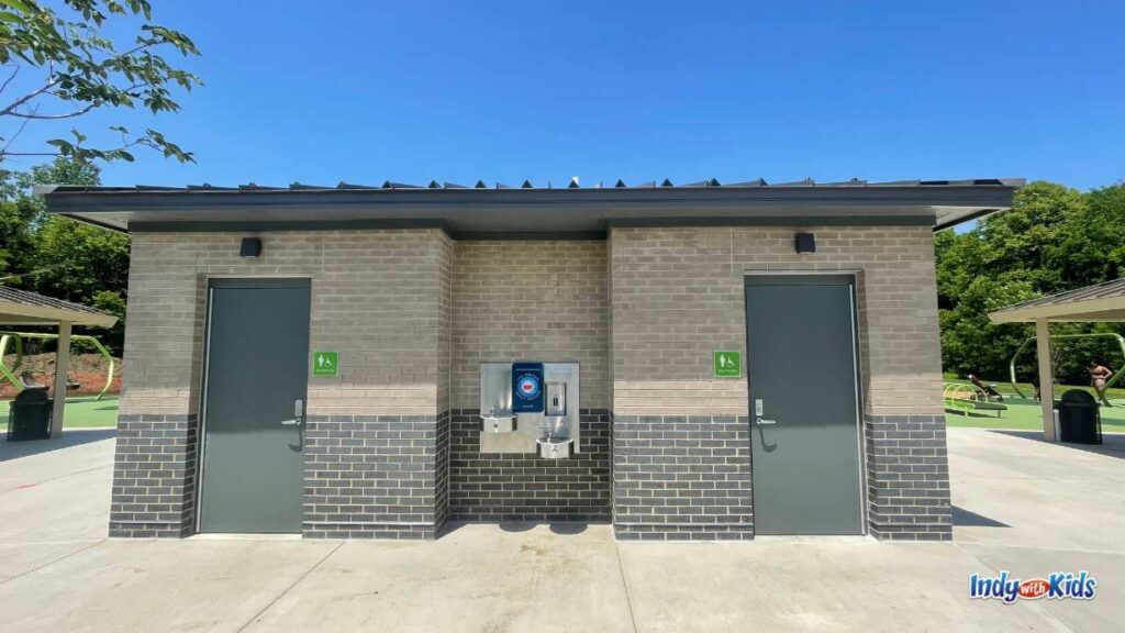 a new restroom building sits in the middle of meadowlark park with two family restrooms flanking a drinking fountain and water bottle filling station