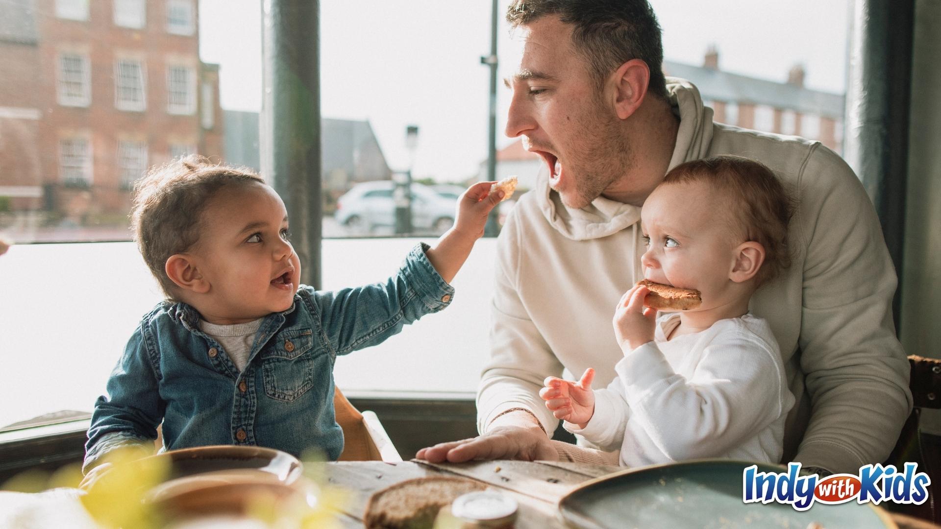 Dad eating pizza with kids