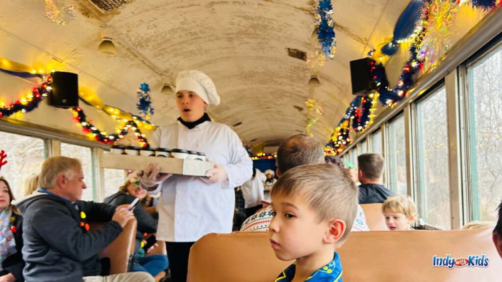 Train Rides in Indiana: a character with a chef's hat hands out cups of hot chocolate on a polar express train ride