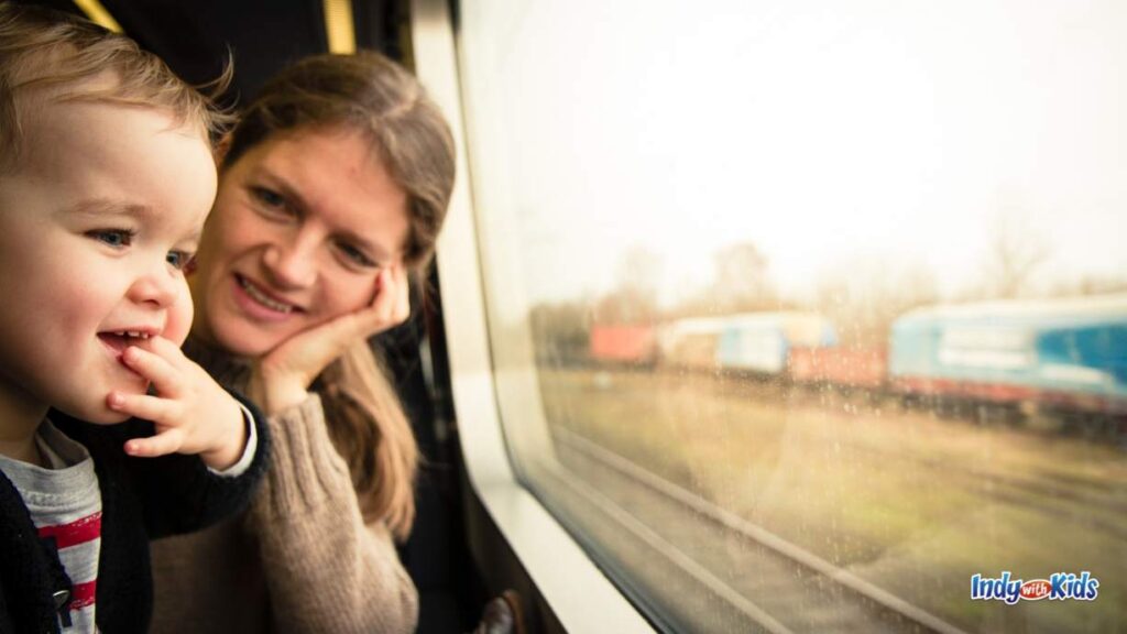 Train Rides in Indiana: a child looks in amazement out the window of a train and his mom looks at him and smiles