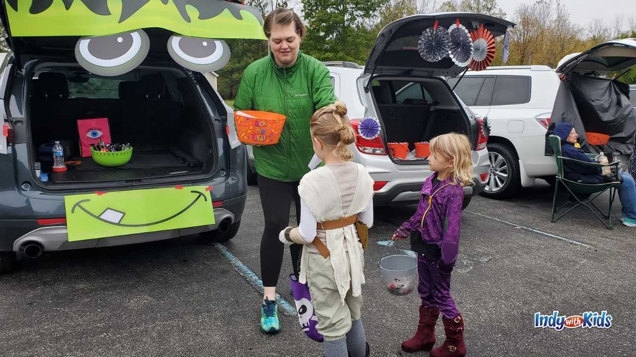 Children receive candy from a costumed volunteer at a local Trunk or Treat event.