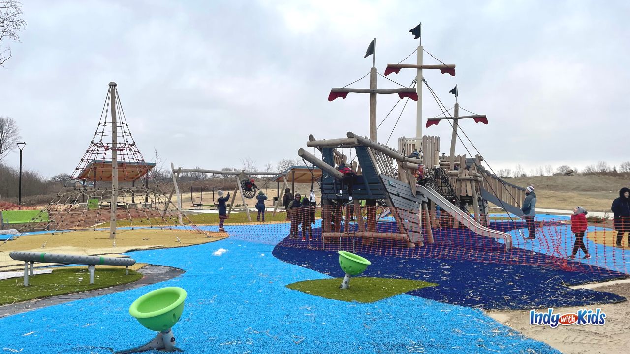 The playground at Geist Waterfront Park features a sailing ship playset, a swing set, a rope climbing gym, and more.