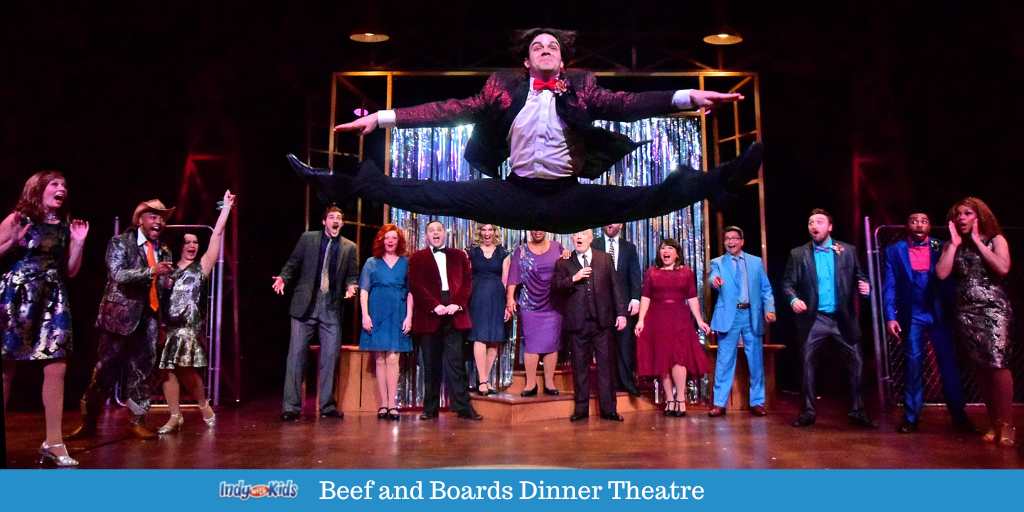 A production of Footloose at Beef and Boards dinner theatre. Character Ren jumps for joy at the end of the production while the cast watches from behind.