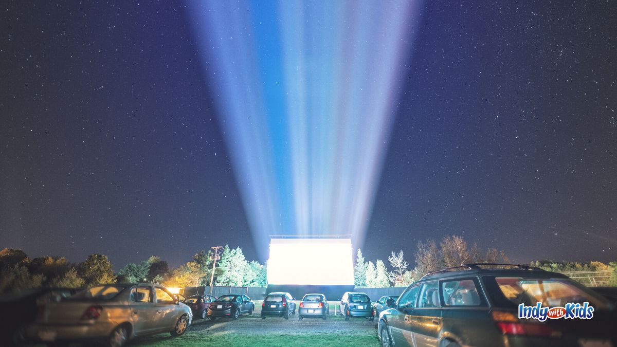 April Date Ideas: Cars surround a glowing screen at a drive-in movie theater.