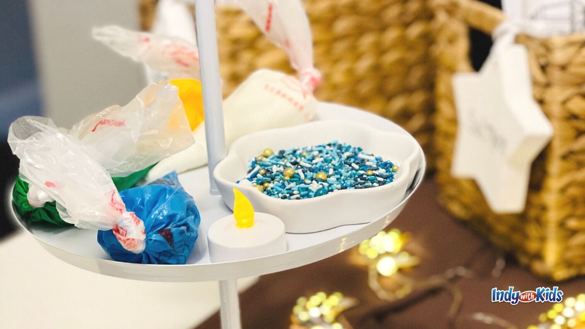 Ramadan Activities: Blue and gold sprinkles fill a dish sitting on a tiered tray alongside decorator's bags of frosting.
