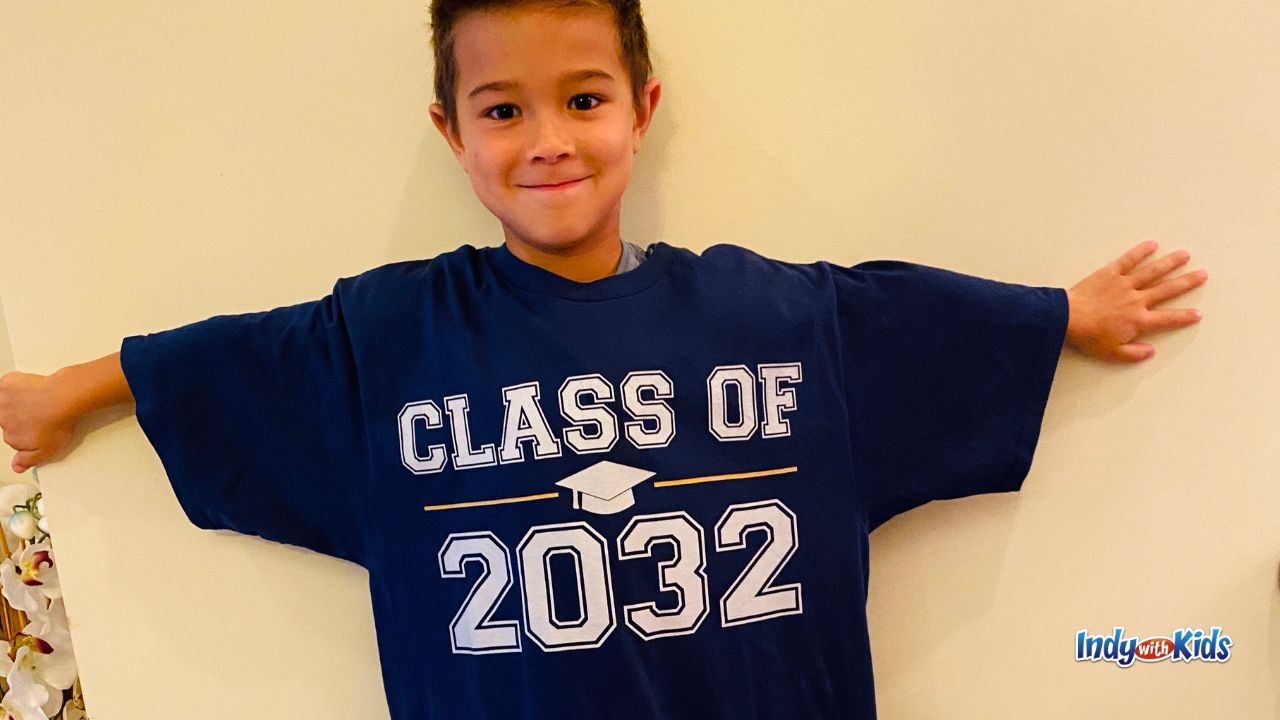 a young boy wears a class of 2032 t-shirt that is several sizes too big for him