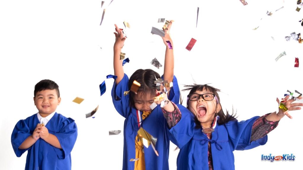 three elementary aged children wearing blue graduation gowns throw confetti in the air and celebrate with last day of school pictures