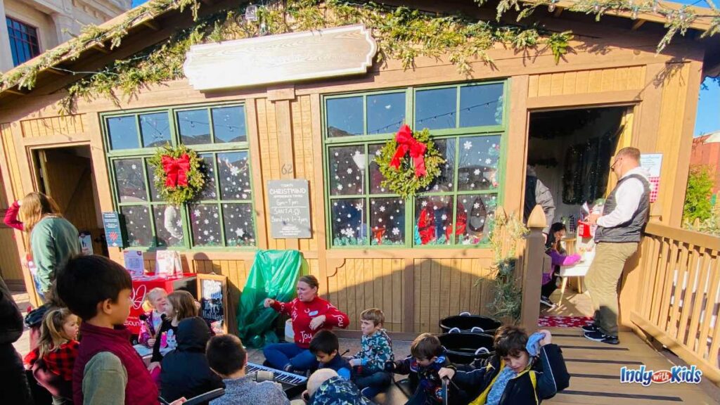 children sit and play musical instruments at the children's hut at the Carmel Christkindlmarkt