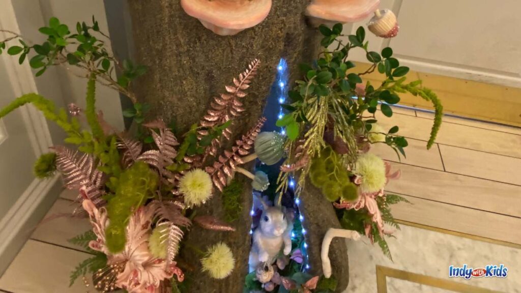 an adorable setup of a bunny in a tree with leaves, plants, and mushrooms sits in the corner of the lobby at the Cake bake shop