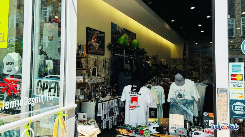 A view into the All Things Carmel store at the Carmel Arts & Design District. There are t-shirts, hats, decor, knick knacks, etc for sale.