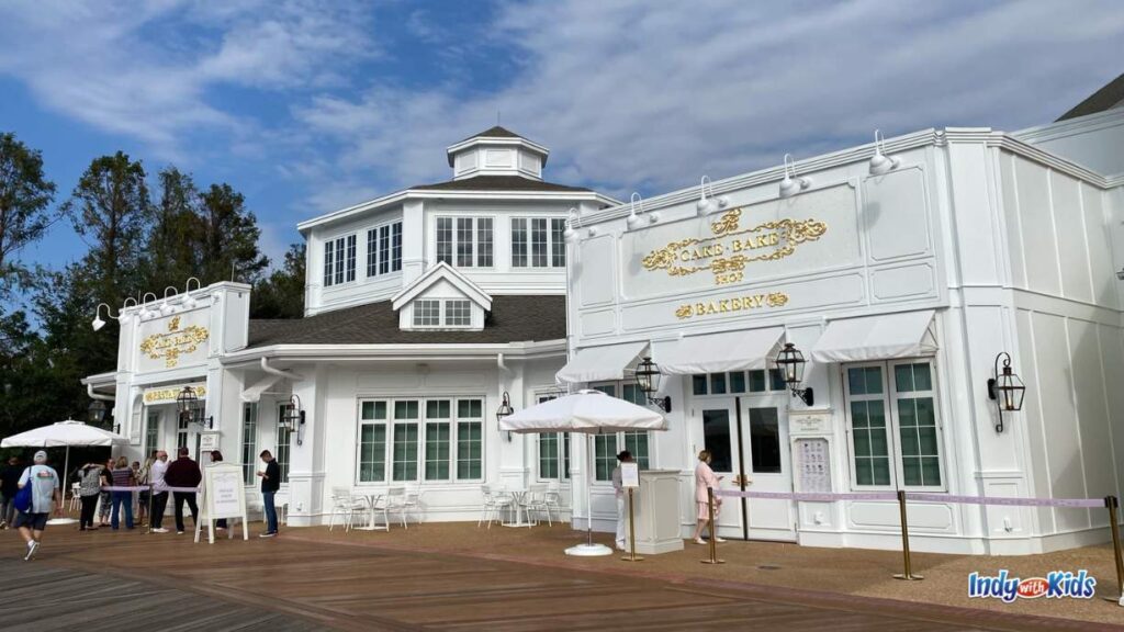 an outdoor view of the cake bake shop disney. the facade is all white with gold lettering.