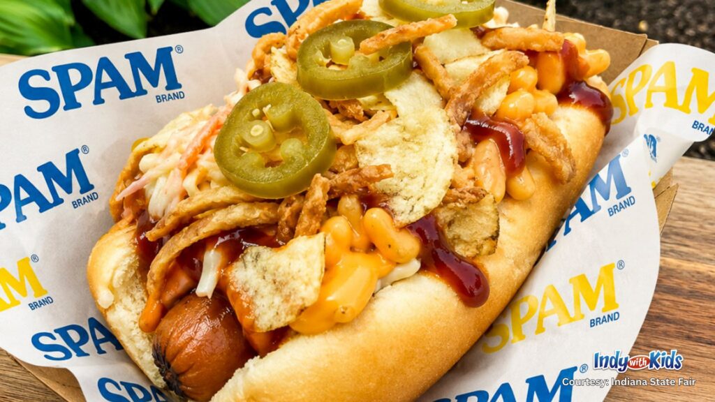 Close-up of an Indiana State Fair hot dog made with SPAM, cheese, potato chips, barbecue sauce, and jalapeño slices.