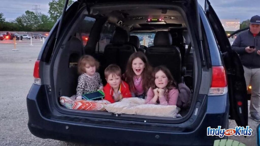 Best Drive In Movie Theater Indianapolis Area: 4 children lay down facing out the back of a minivan ready to watch a movie at the drive in.