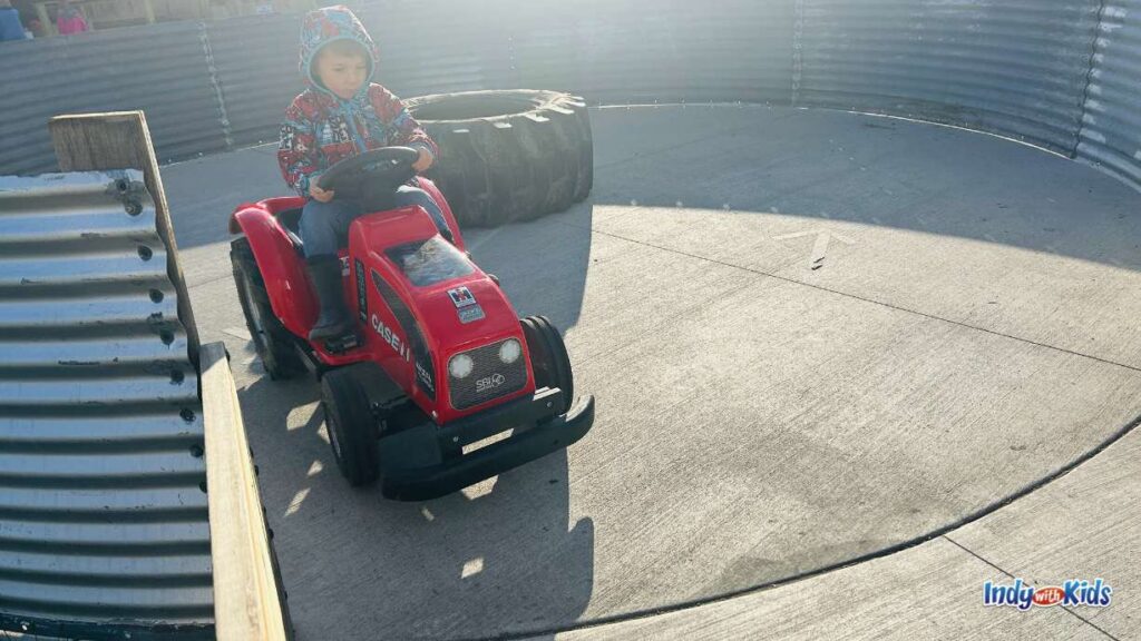 Dull’s Tree Farm and Pumpkin Harvest: a little boy sits in a red power wheels-style electric tractor