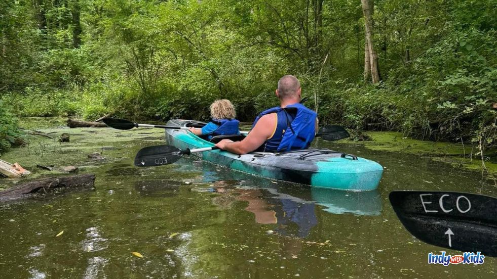 A man and child rest in a quiet cove while kayaking the reservoir at Eagle Creek Park.