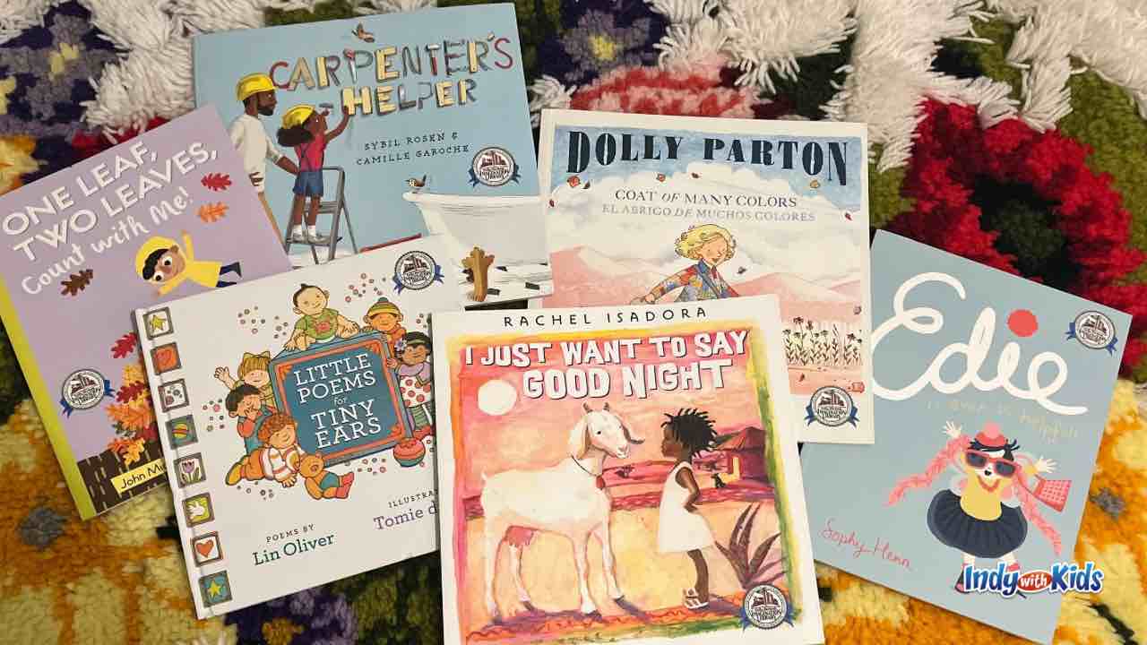 an assortment of preschool books from Dolly Parton's Imagination Library lie on a carpet 