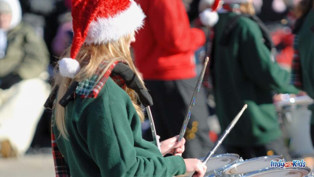 Indianapolis Christmas Parades 2024: a drummer in a parade dons a red Santa hat