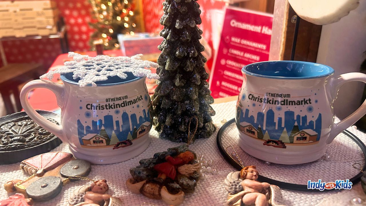 A close up of two mugs with logos from the Athenaeum Christkindlmarkt in Indianapolis.