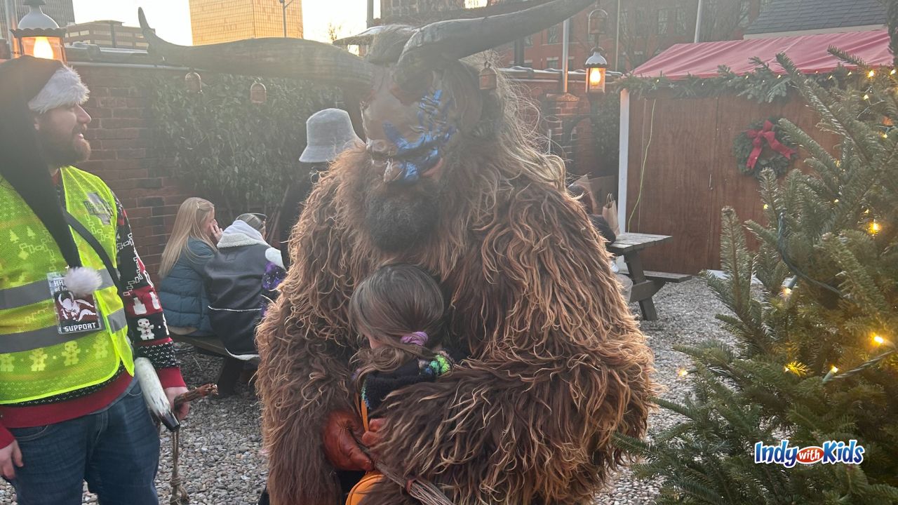 A girl hugs a costumed Krampus character at the Athenaeum Christkindlmarkt in Indianapolis.