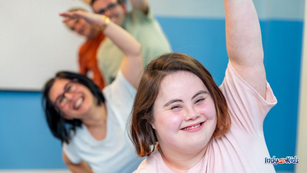 January Events for Kids with Special Needs: A teen with Down syndrome curves her arm above her head in an adaptive ballet class.