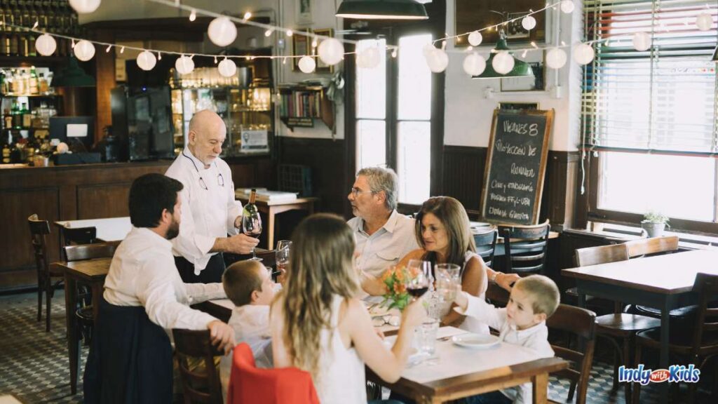 Things to Do in Indianapolis in February - a family sits down at a nice restaurant ordering from a waiter