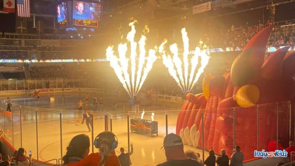 Indy Fuel Hockey Games for Kids: tall flames ignite the hockey rink next to an inflatable bounce house of the Indy fuel mascot