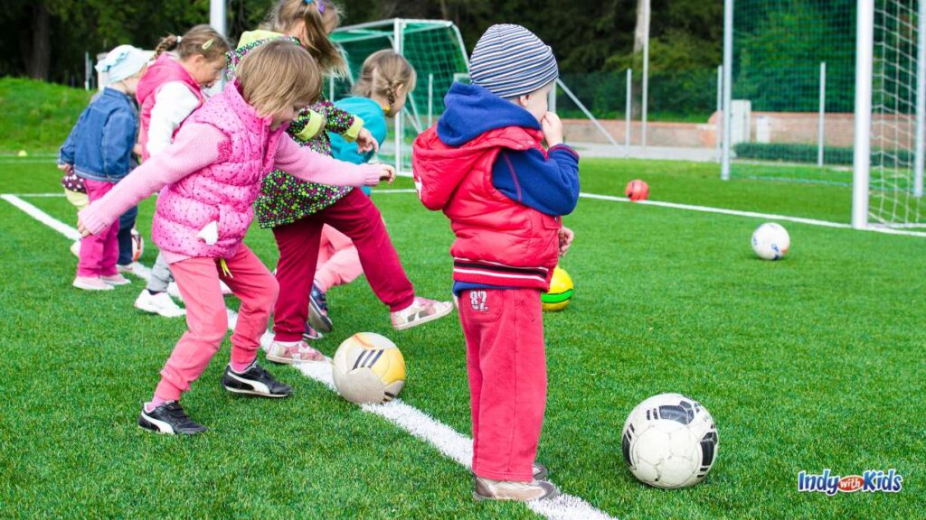 Off the Wall Sports Carmel: a line of little kids outside working with soccer balls during a lesson