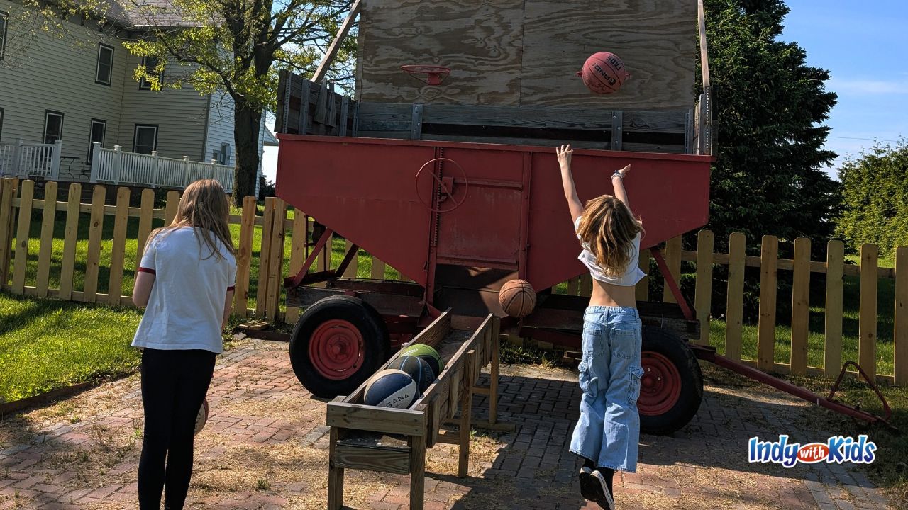 Two girls play basketball using a hoop on the side of a barn at Woolly Yak Ranch and Winery in Arcadia, Indiana.