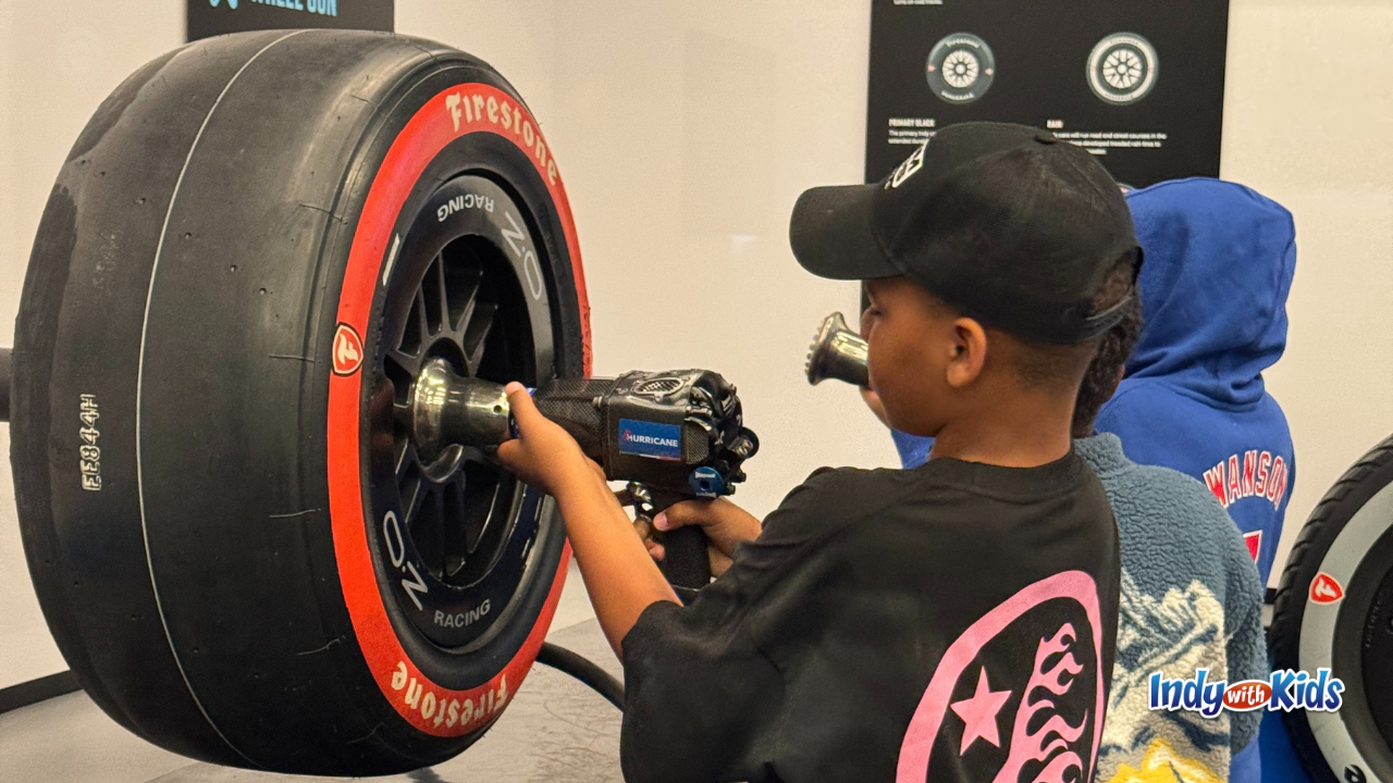 Indianapolis Motor Speedway Museum Summer Camp Boy holding a racecar changing tool