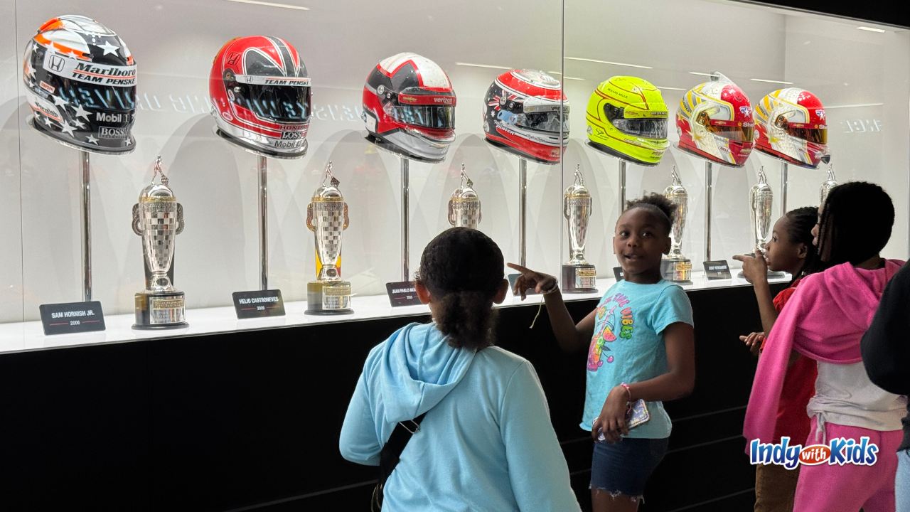 Indianapolis Motor Speedway Museum Summer Camp girls looking at Penske Helmets​