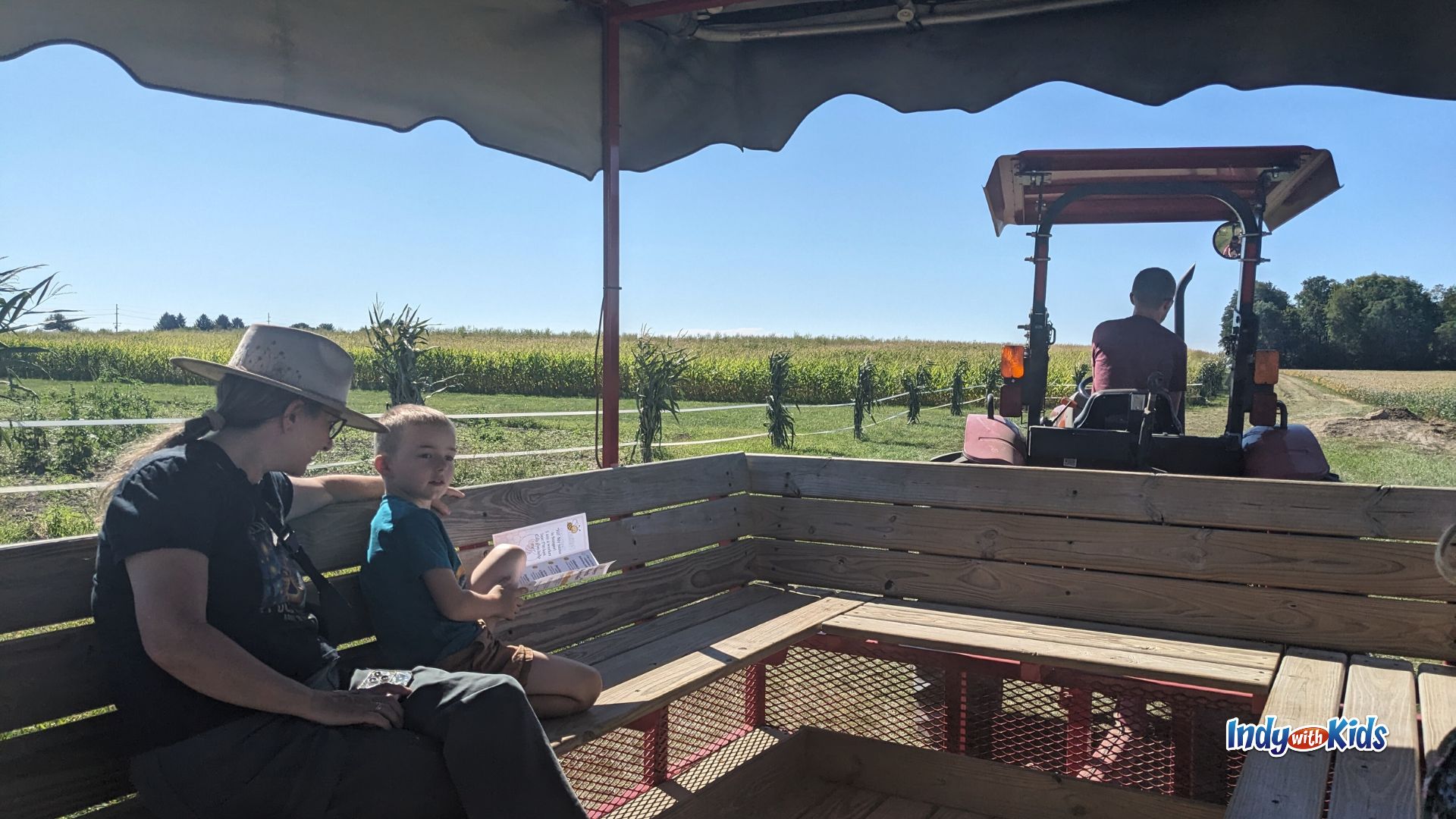 A woman and a child ride in a wagon pulled by a tractor at Tuttle Orchards in Greenfield.