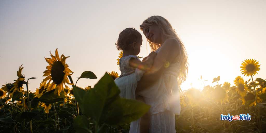 mother and child in sunflower field at dusk