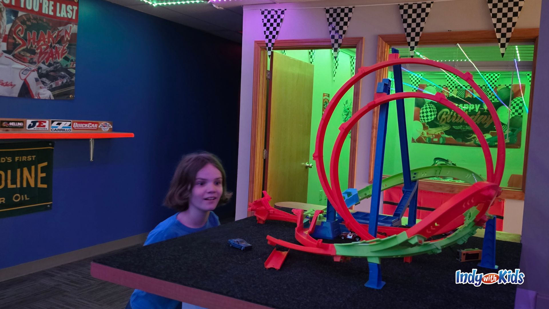 Child looking at a double-loop Hot Wheels track setup inside SpeedZone in Martinsville.