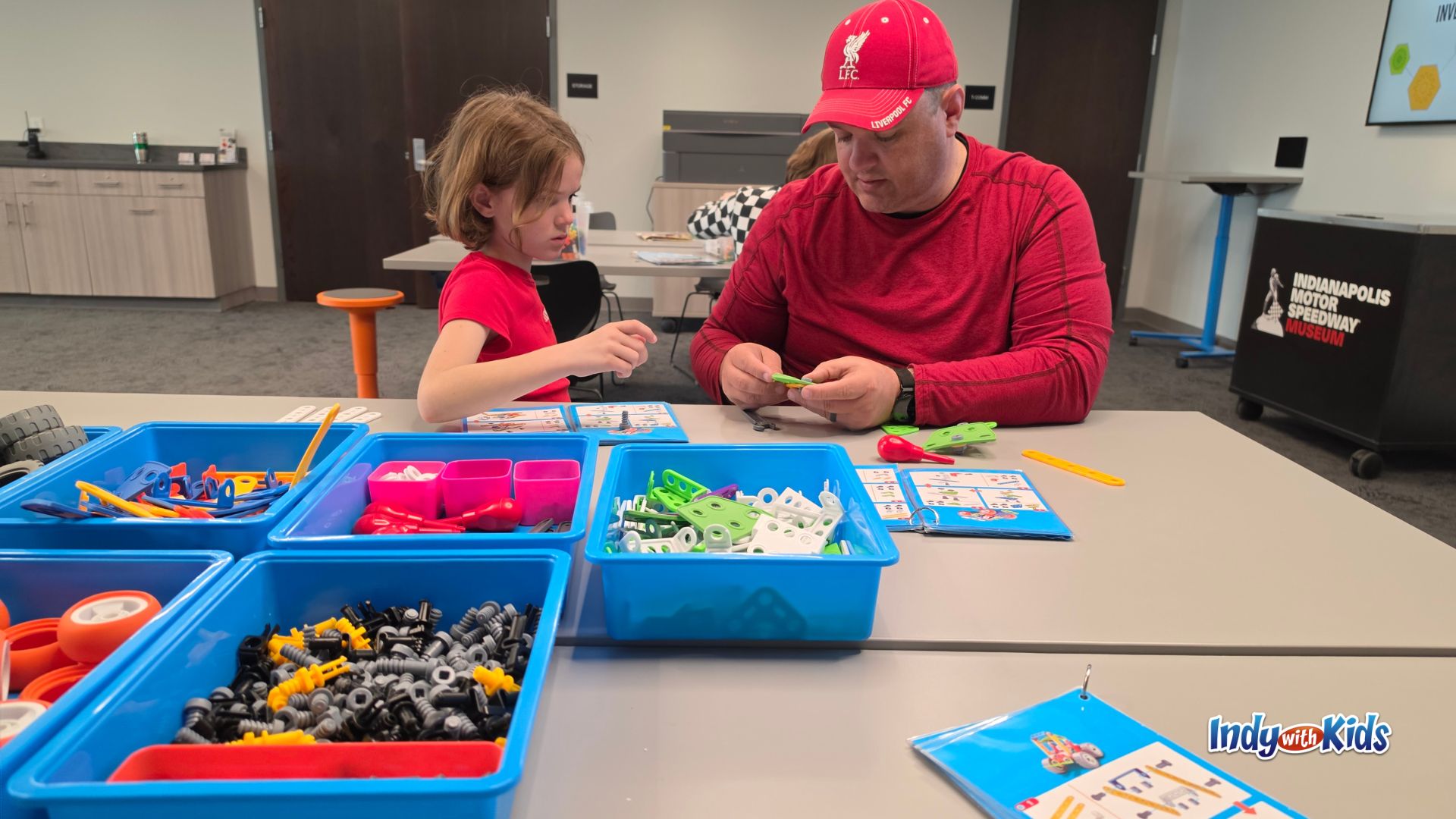 A child and adult build a model race car together using colorful construction pieces in the Allen Whitehill Clowes Charitable Foundation Innovation Workshop at the Indianapolis Motor Speedway Museum.