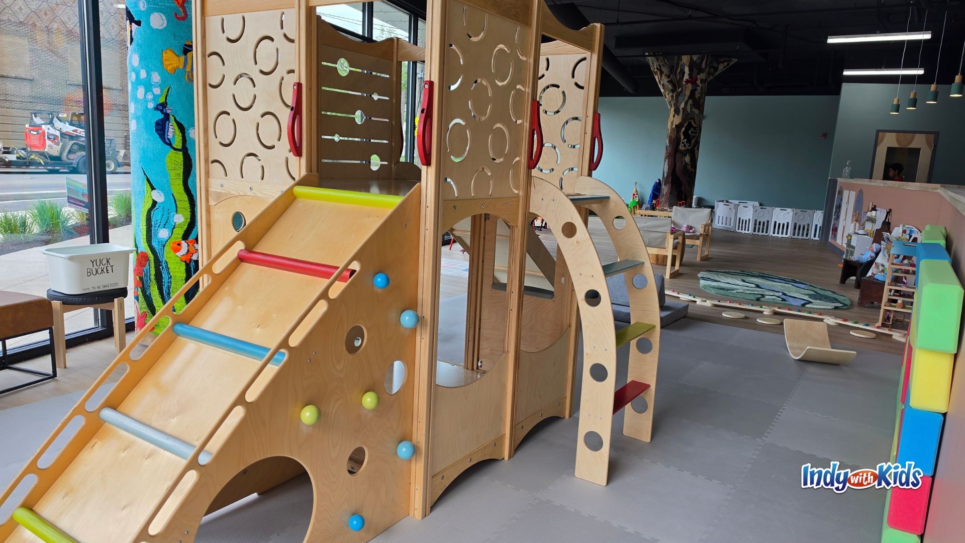 The Nest Play Café indoor play area in Indianapolis with a wooden climbing structure and slide