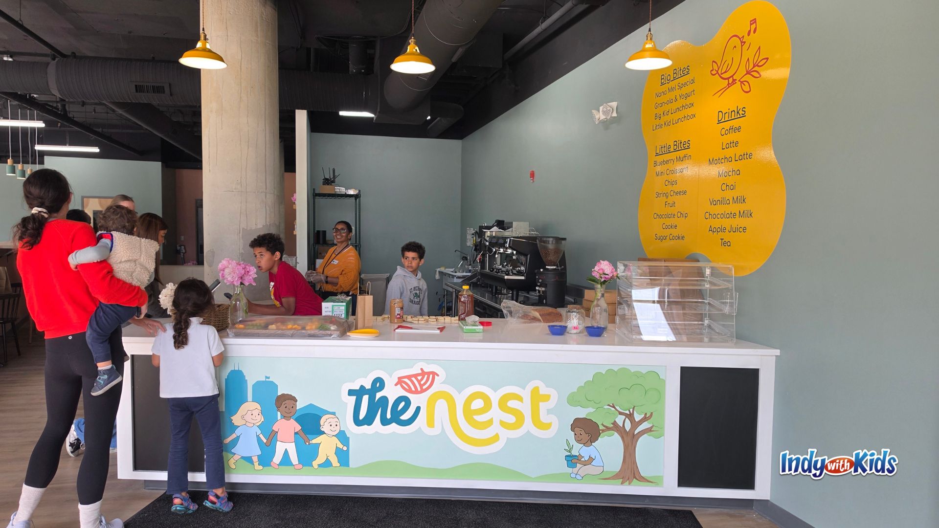 Families ordering snacks and drinks at The Nest Play Café counter in Indianapolis