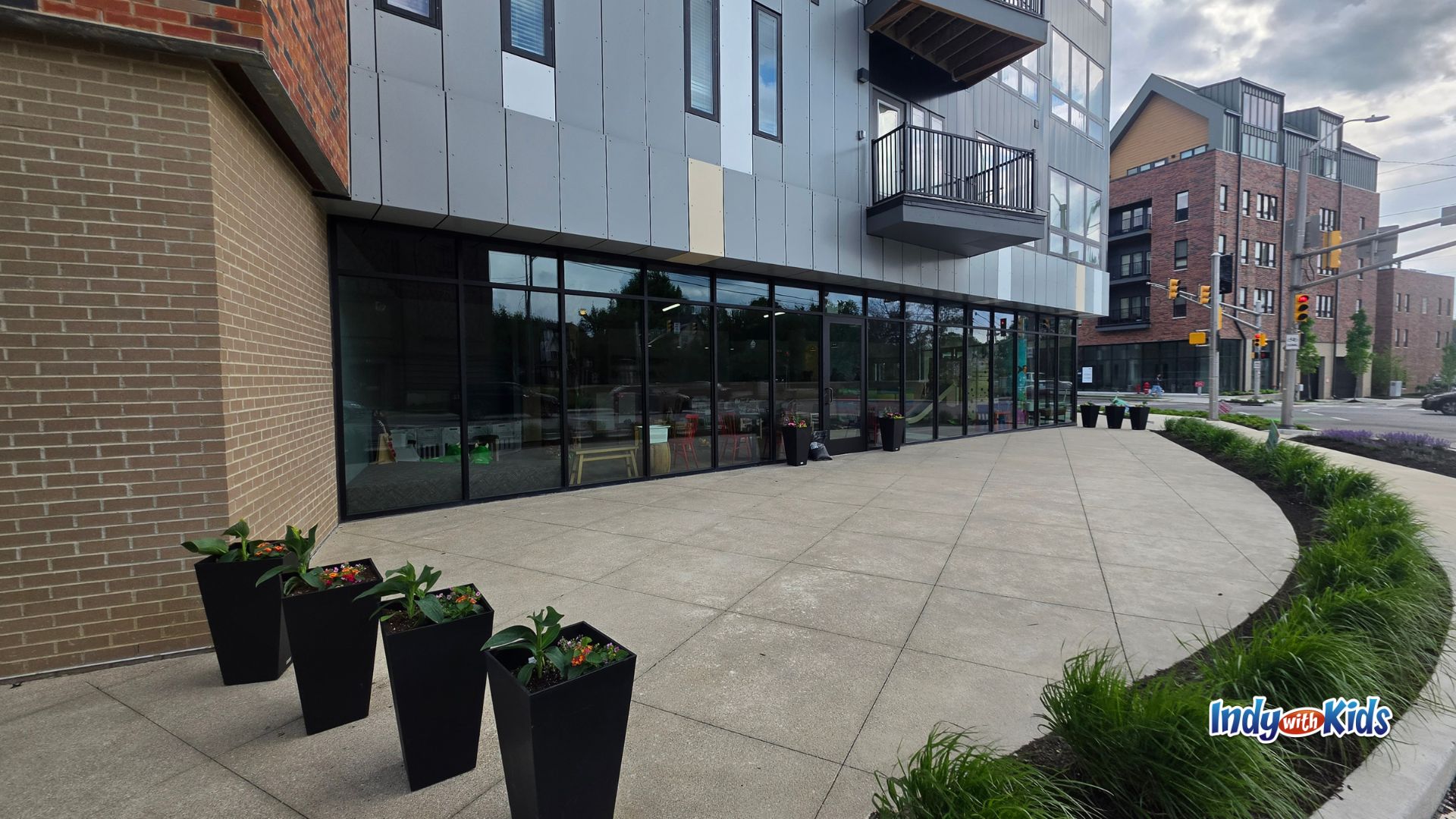 Exterior of The Nest Play Café in Indianapolis with large windows, patio space, and planters